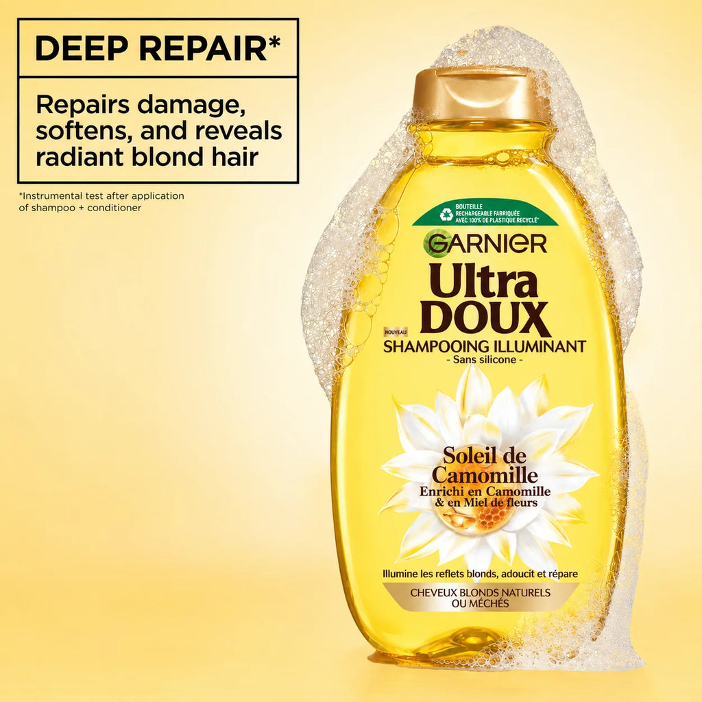 Garnier Ultra Doux camomile and flower honey illuminating shampoo bottle with light yellow liquid and floral label design