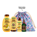 Garnier avocado shampoo, conditioner, leave-in treatment, and serum set arranged on a bathroom shelf.