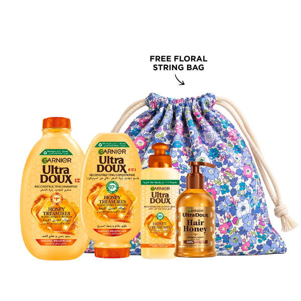 Garnier Honey Treasures shampoo, conditioner, leave-in, and serum set with honey-infused hair care products in bottles and tubes.