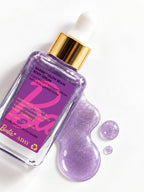 ADAY x Barbie Glow Beam Body Serum lying beside a pool of lilac shimmer serum