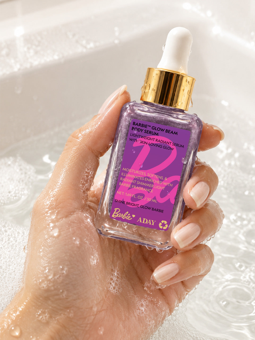 Hand holding the ADAY x Barbie Glow Beam Body Serum bottle above water