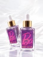 Front and back of the ADAY x Barbie Glow Beam Body Serum bottle showing the label