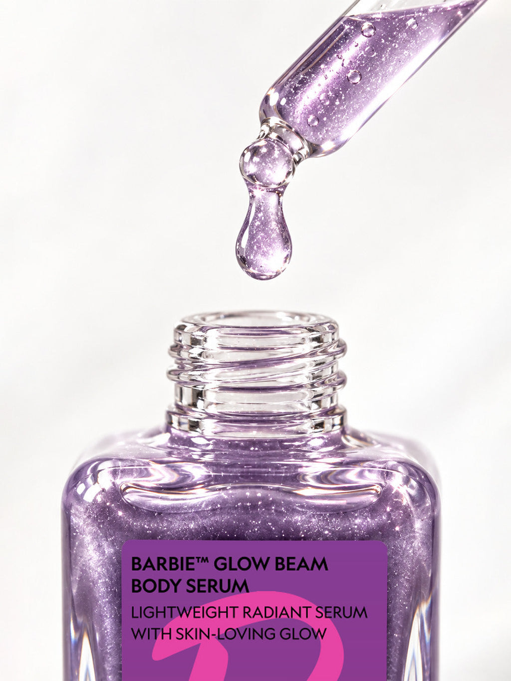 Close-up of the ADAY x Barbie Glow Beam dropper releasing a drop of lilac shimmer serum
