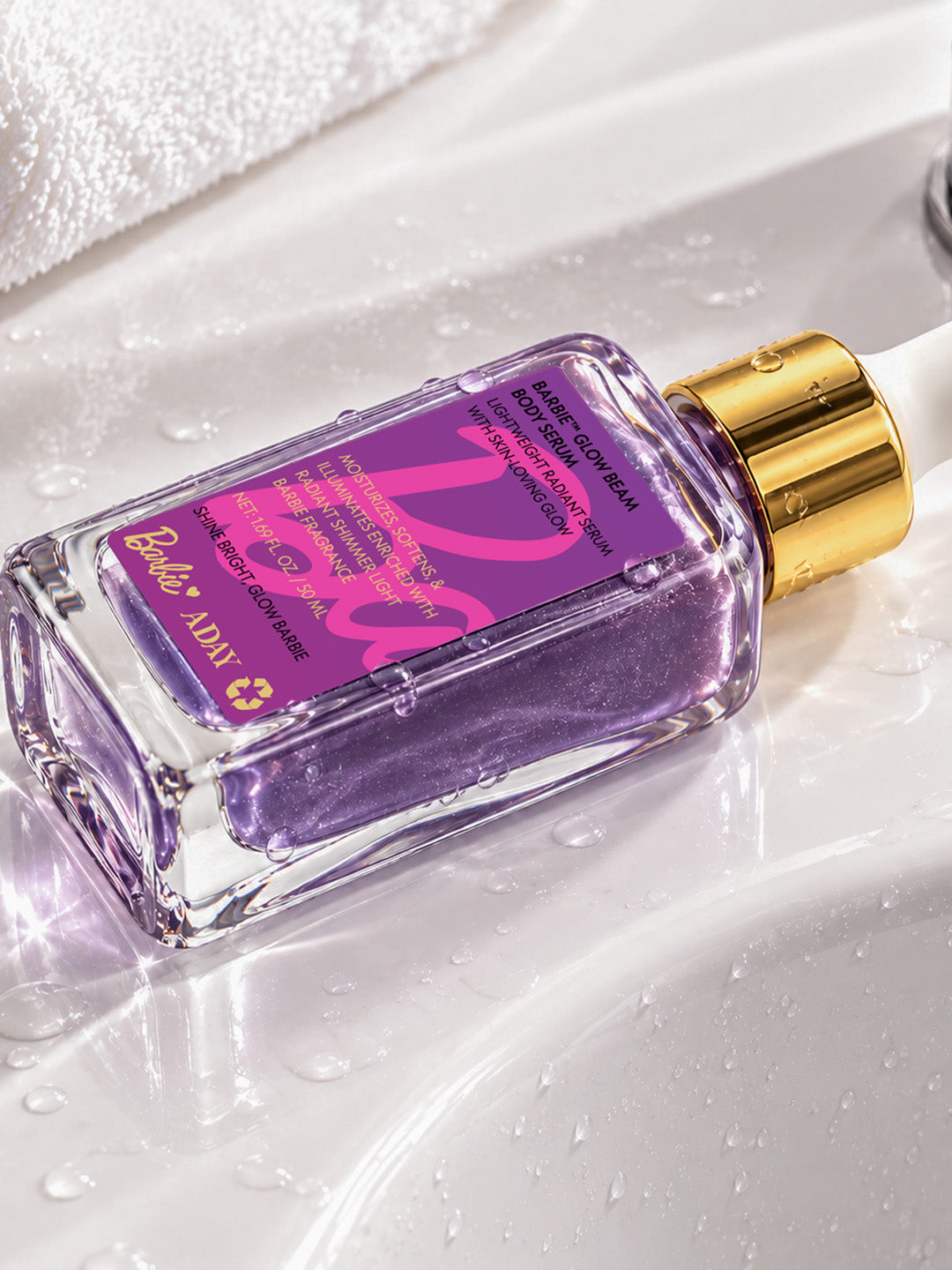 Close-up of the ADAY x Barbie Glow Beam Body Serum label on a wet white surface