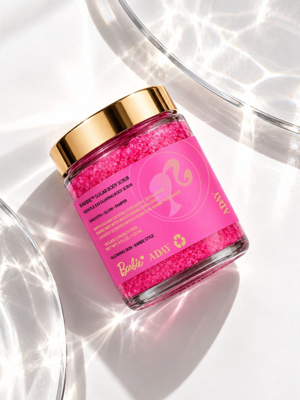 ADAY x Barbie Sugar Body Scrub tilted on a glass surface in sunlight