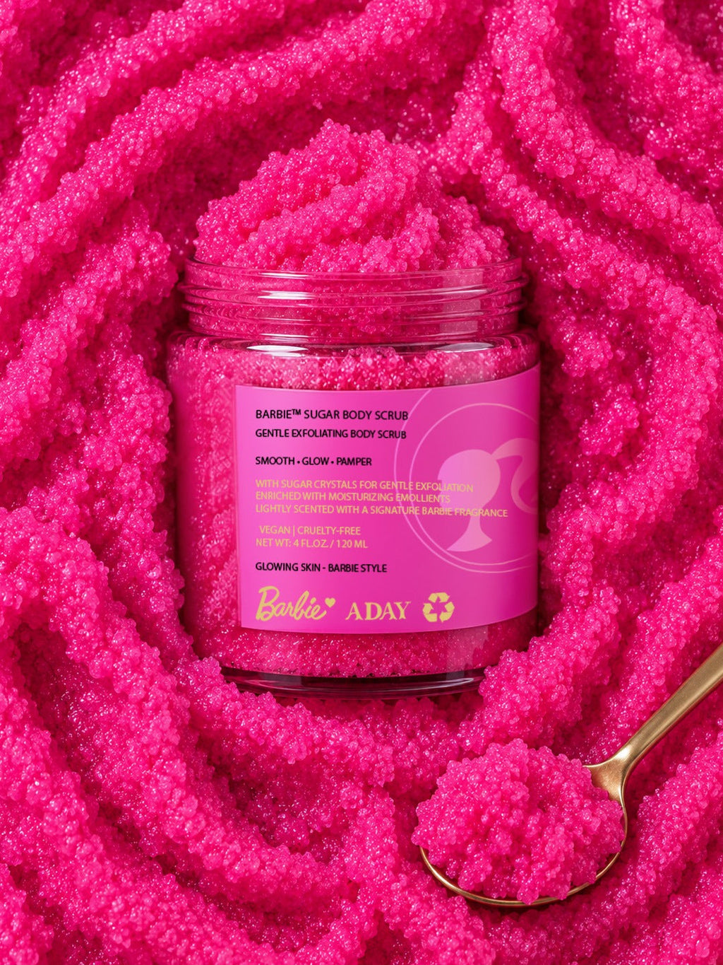 ADAY x Barbie Sugar Body Scrub set in a swirl of pink scrub with a gold spoon