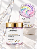 Two jars of ADAY Cloud Swirl Whipped Body Butter, one open to show the rainbow swirl