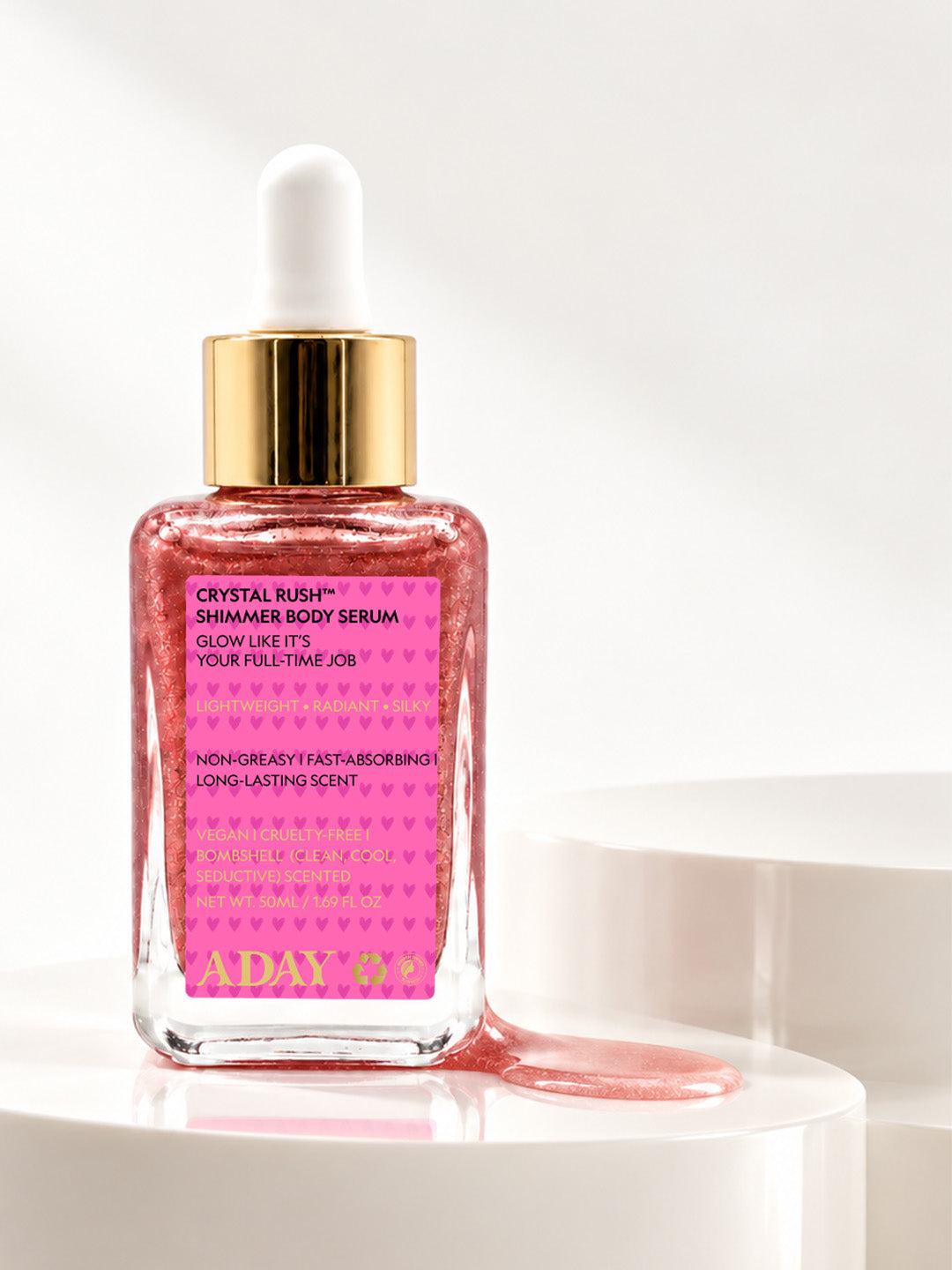 ADAY Crystal Rush Shimmer Body Serum, a 50 ml glass dropper bottle of pink shimmer on a white pedestal