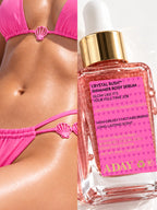 ADAY Crystal Rush Shimmer Body Serum held against a model's midriff in pink swimwear