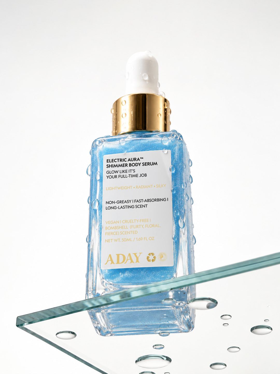 ADAY Electric Aura Shimmer Body Serum standing on a glass sheet scattered with water droplets