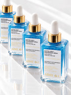 Four bottles of ADAY Electric Aura Shimmer Body Serum in a row on white