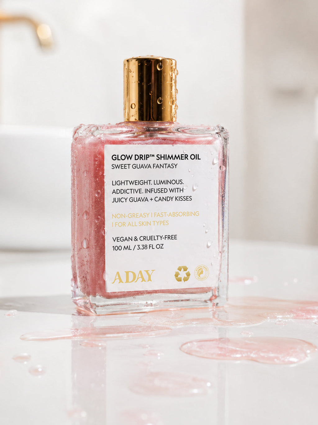 ADAY Glow Drip Shimmer Oil standing in a pool of spilled pink shimmer oil