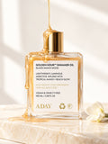 ADAY Golden Hour Shimmer Oil in Island Manoi Mood, a 100 ml gold-capped glass bottle with honey drizzling over it
