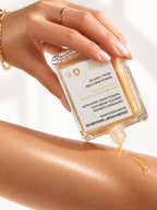 A hand tipping the ADAY Golden Hour Shimmer Oil, gold oil running onto a forearm