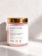 ADAY Rosy Crush Salt Scrub in Blush Bloom, a 200 g glass jar with a gold lid