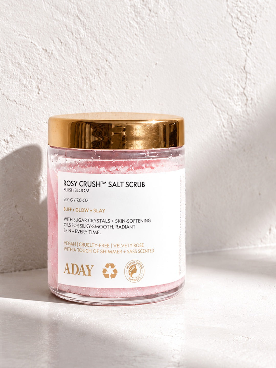 ADAY Rosy Crush Salt Scrub in Blush Bloom, a 200 g glass jar with a gold lid
