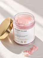 An open jar of ADAY Rosy Crush Salt Scrub with its gold lid resting alongside