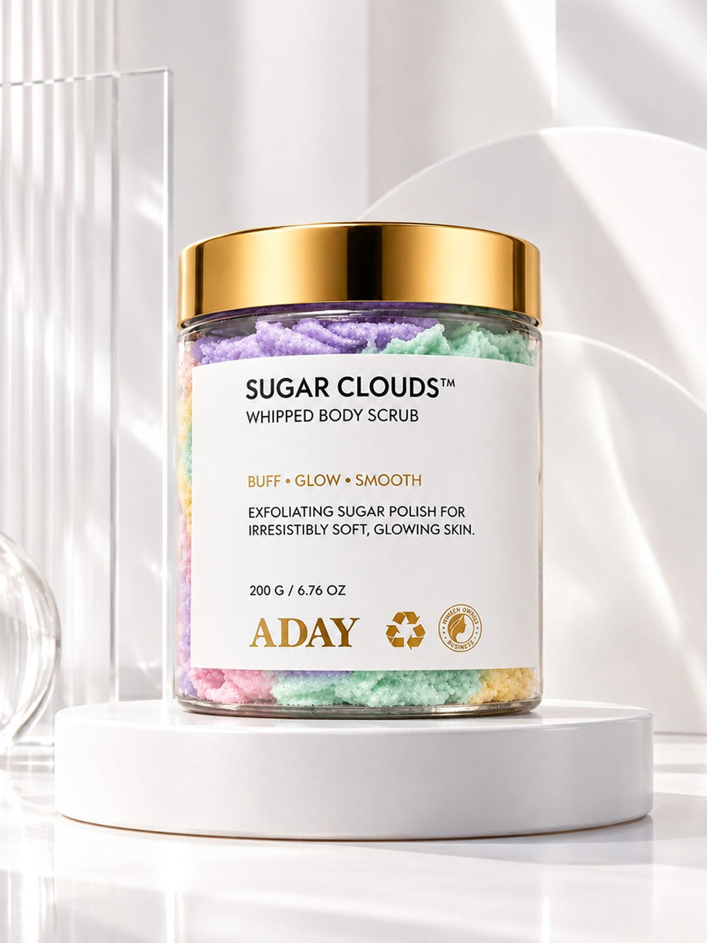 ADAY Sugar Clouds Whipped Body Scrub, a 200 g jar with a gold lid, on a white pedestal