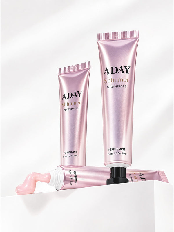 Two tubes of ADAY Pink Shimmer Toothpaste on white plinths, one with a curl of paste