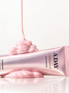 Pink shimmer paste pouring over the ADAY Pink Shimmer Toothpaste tube