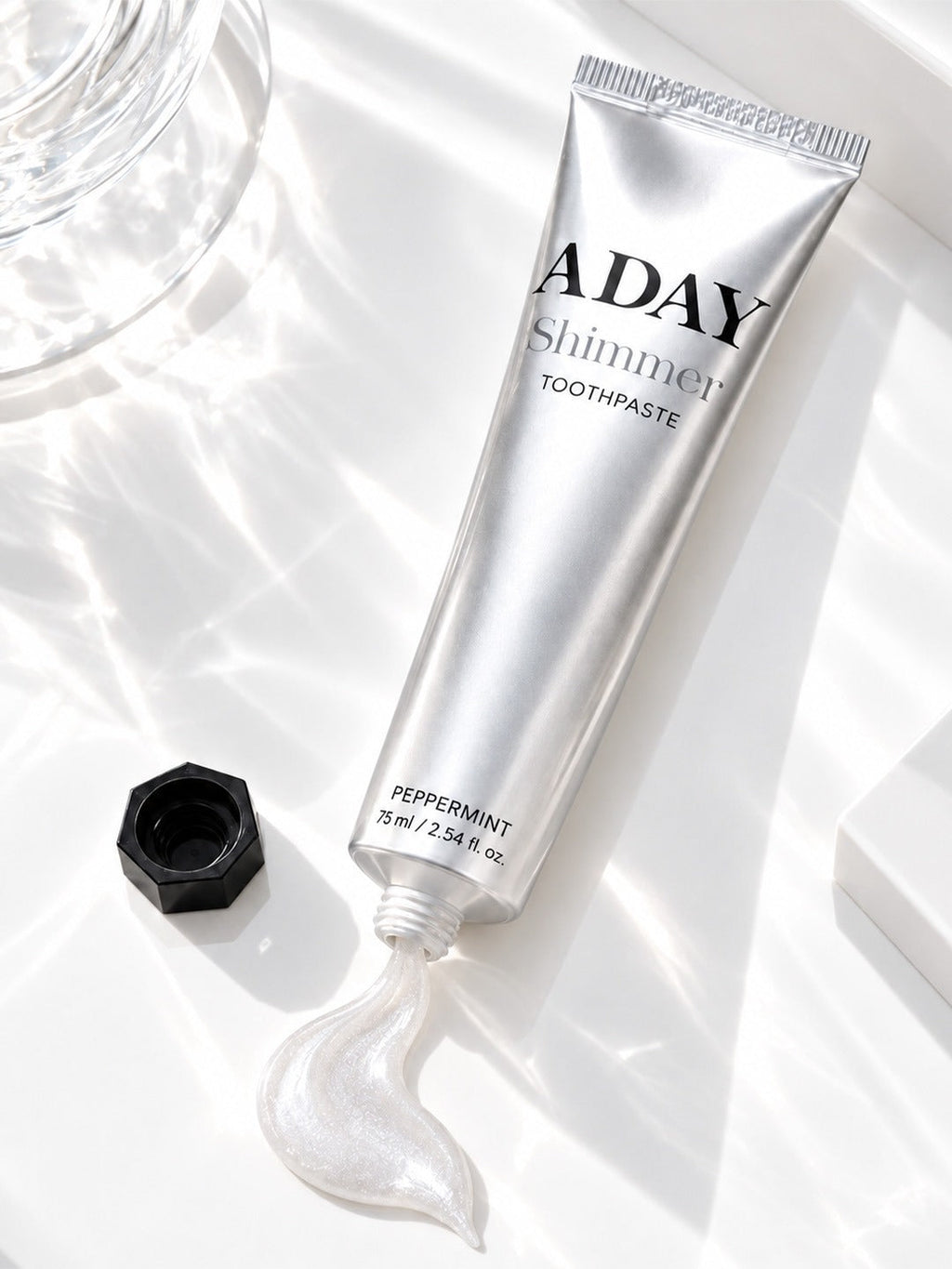 ADAY Silver Shimmer Toothpaste lying open with a curl of paste beside it