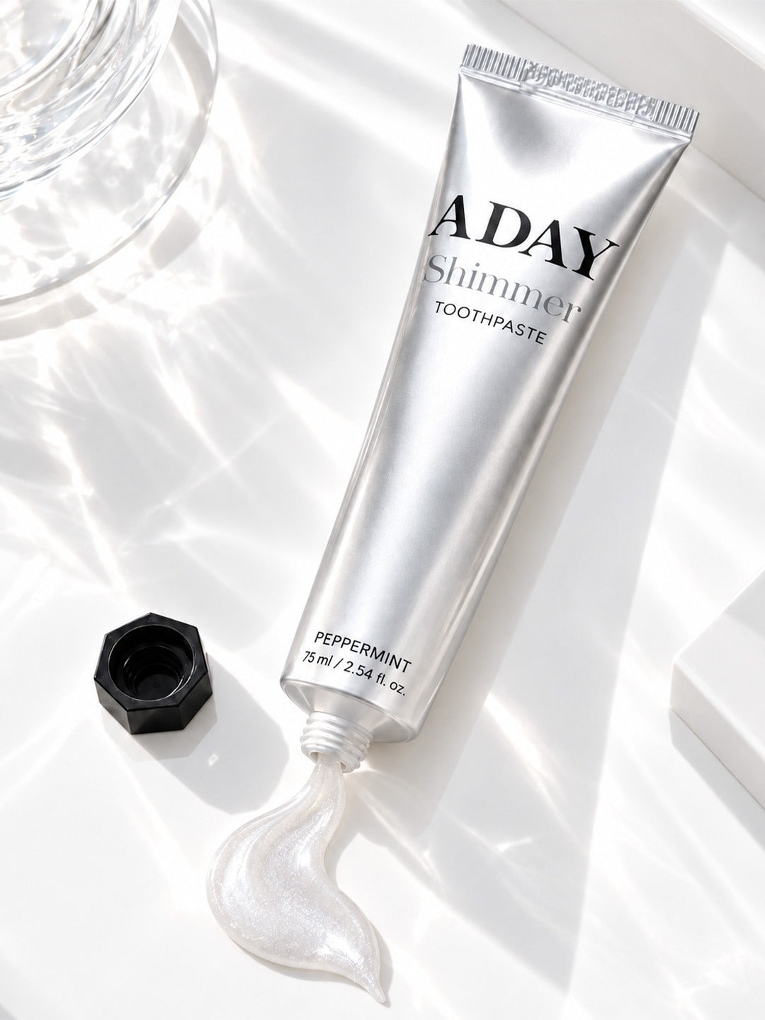 ADAY Silver Shimmer Toothpaste lying open with a curl of paste beside it