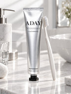 ADAY Silver Shimmer Toothpaste standing on a marble vanity beside a toothbrush
