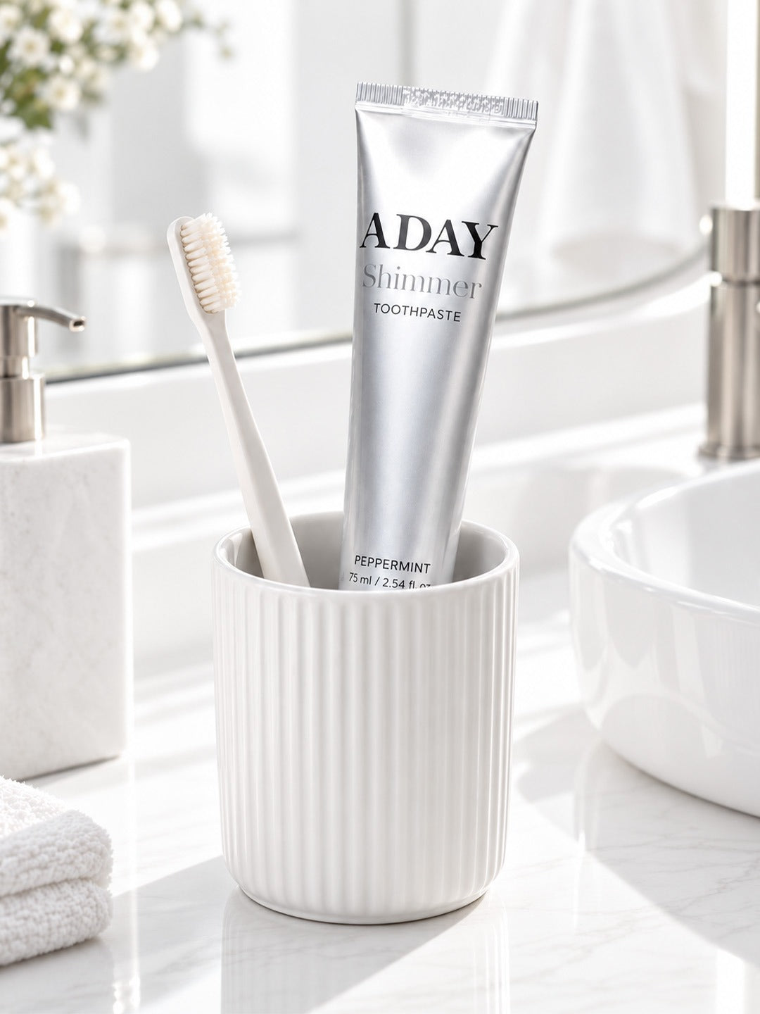 ADAY Silver Shimmer Toothpaste in a ceramic cup with a toothbrush