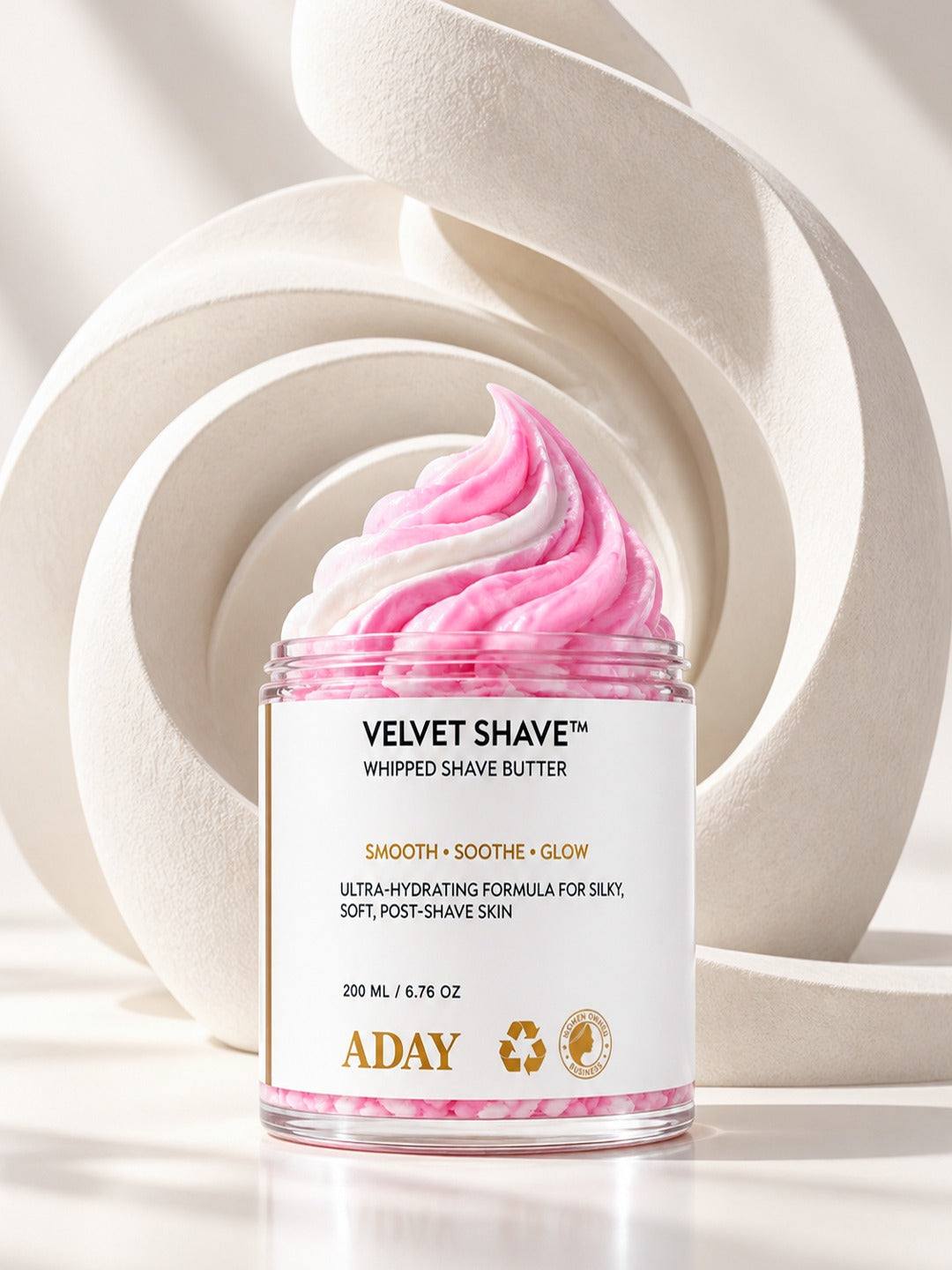 ADAY Velvet Shave Whipped Shave Butter in front of sculptural white arches