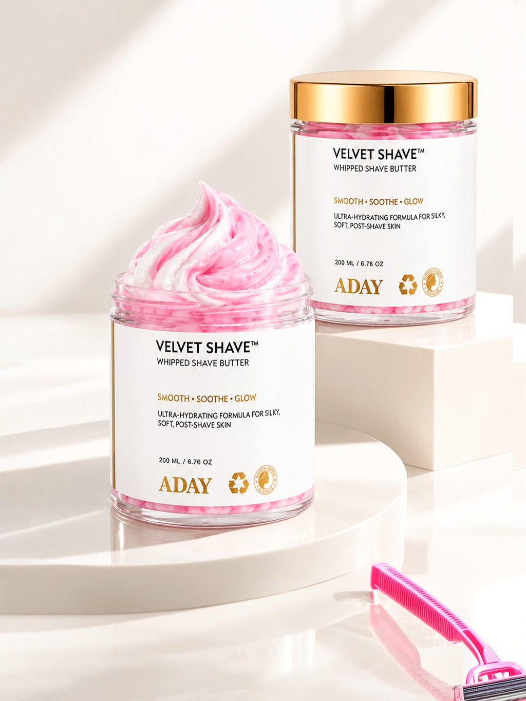 Two jars of ADAY Velvet Shave Whipped Shave Butter on white plinths, one open to show the whipped peak