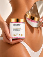 A model holding the ADAY Velvet Shave Whipped Shave Butter beside a curved gold mirror